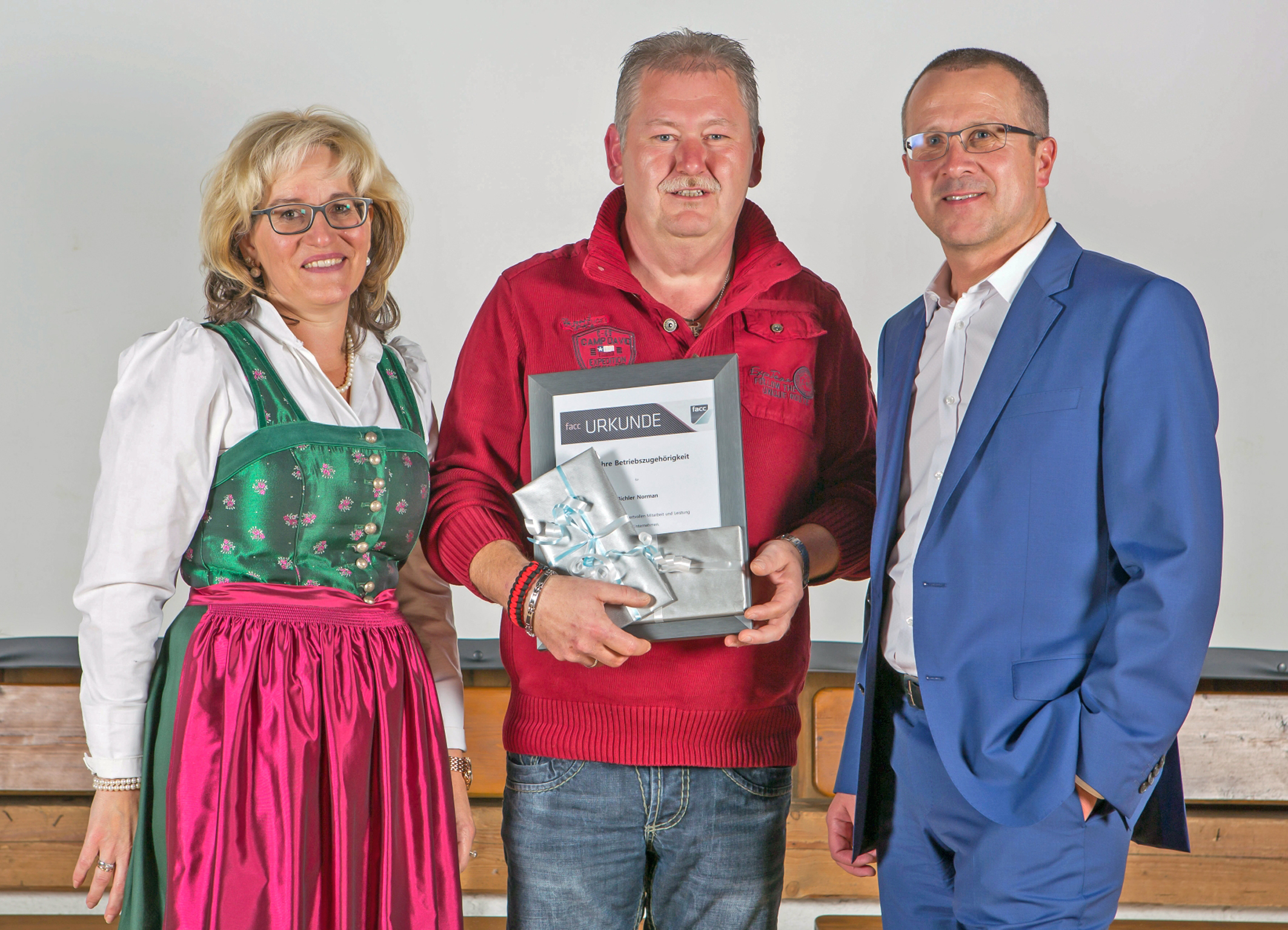 Norman Bichler (Bildmitte) ist seit 35 Jahren Mitglied der FACC-Crew. Betriebsrätin Barbara Huber (links) und FACC-Vorstand Robert Machtlinger (rechts) ehrten den langjährigen Mitarbeiter. Foto: Christoph Hatheuer/FACC AG (frei)