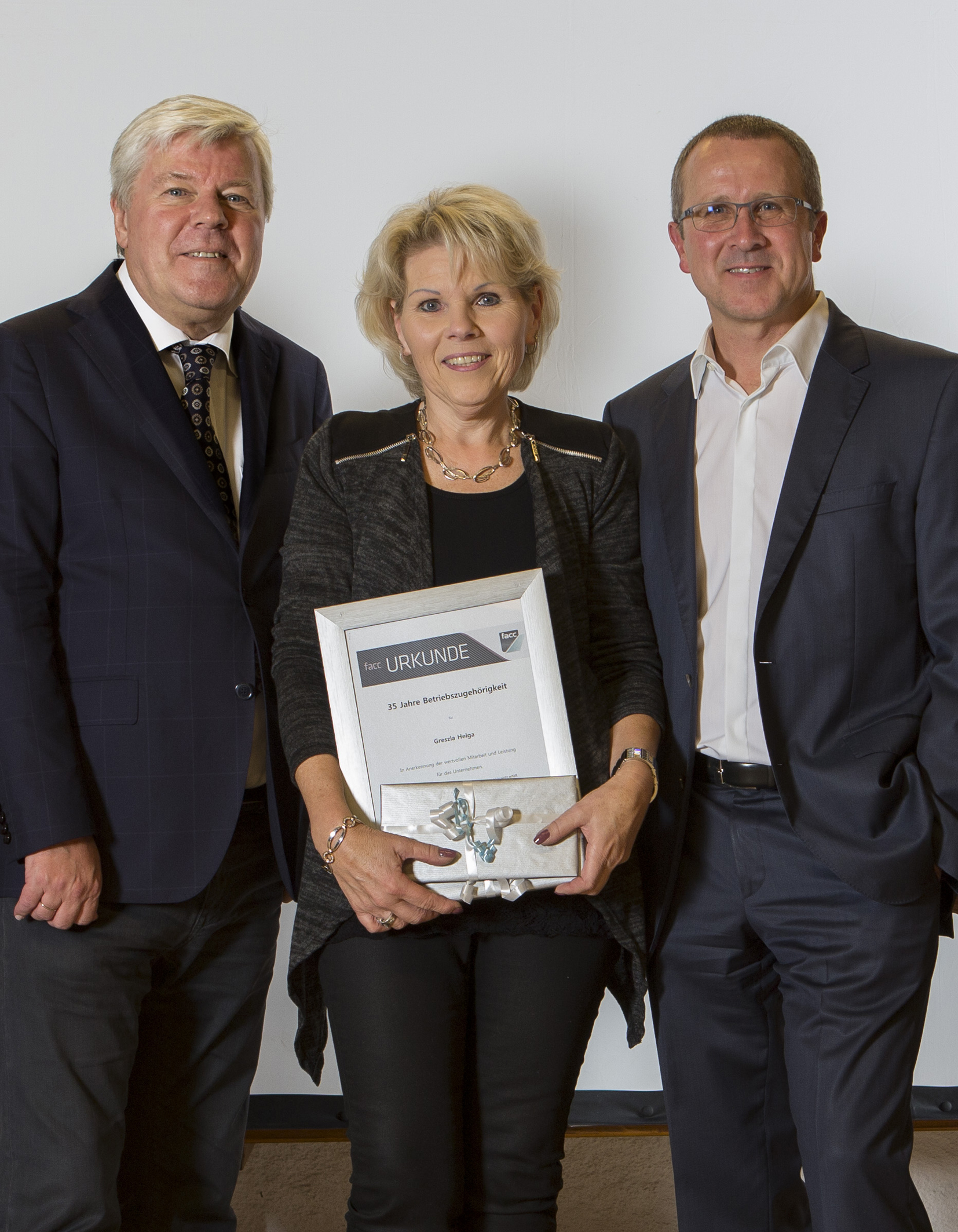 Die FACC-Vorstände Walter A. Stephan und Robert Machtlinger mit Jubilarin Helga Greszla, die für ihre 35jährige Treue geehrt wurde. Foto: Alois Furtner/FACC (frei)