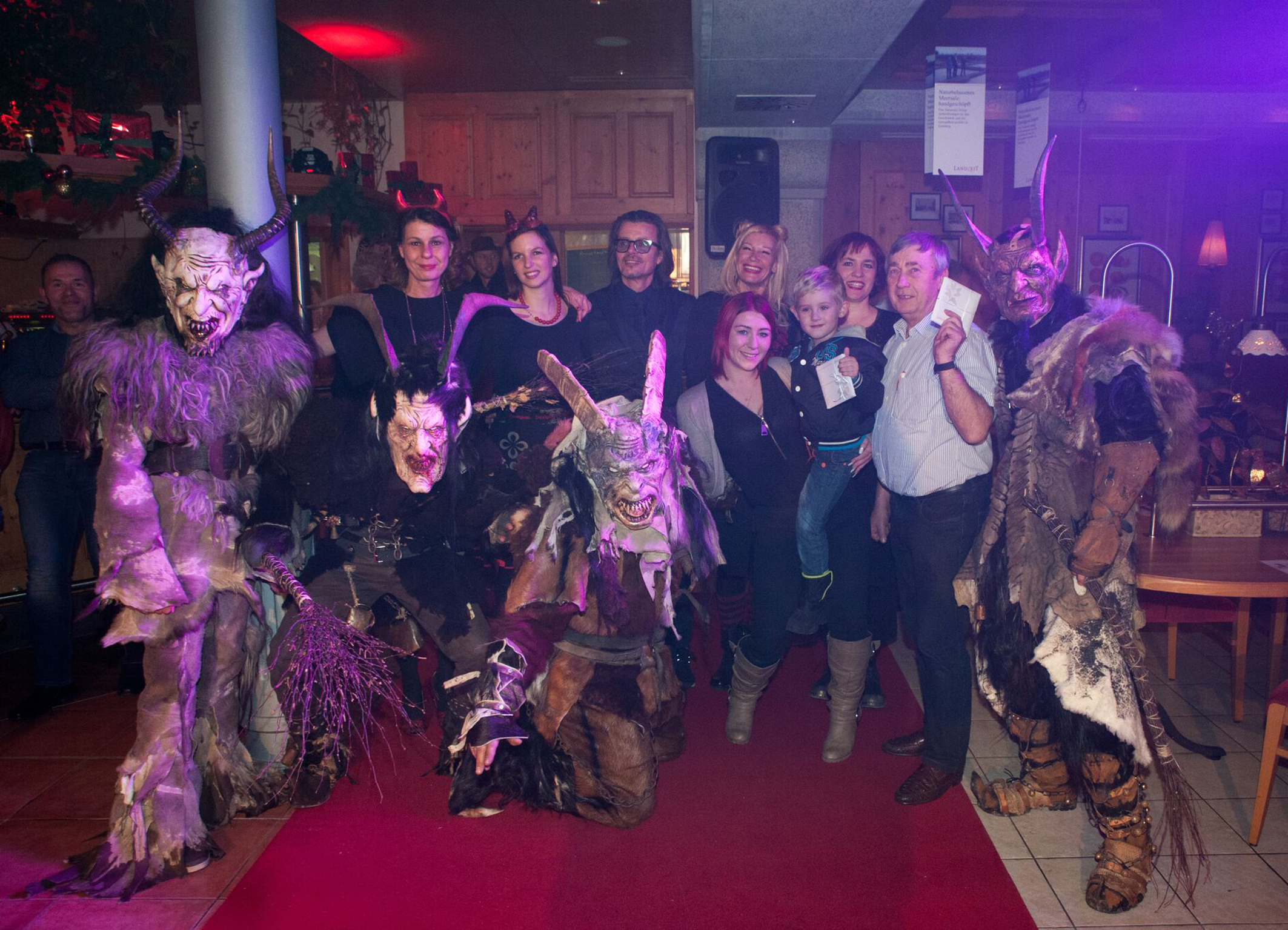 Julia Mauracher (2. Reihe, 2. v. l.) und Josef Gruber (2. v. r.) wurden im Landzeit-Restaurant St. Valentin zu „the best dressed Miss und Mister Krampus“ gewählt. Einen Sonderpreis gab es für Alexandra Walzer und ihren Sohn (1. Reihe, 3. v. r.). Foto: Christoph Schruf